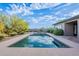Backyard pool with blue skies reflecting off the water, framed by desert vegetation at 6069 E Ironwood Dr, Scottsdale, AZ 85266