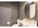 This powder room features chic tile work and gold fixtures and accents at 6069 E Ironwood Dr, Scottsdale, AZ 85266