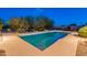 Sparkling swimming pool with a geometric design, surrounded by lush greenery and desert landscaping at 6069 E Ironwood Dr, Scottsdale, AZ 85266