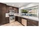 Modern kitchen featuring stainless steel appliances, stylish countertops, and warm-toned tile flooring at 6119 E Sandra Ter, Scottsdale, AZ 85254