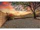 Gravel backyard featuring blooming bushes, metal fence with beautiful mountain views at sunset at 6520 E Hacienda La Noria Ln, Gold Canyon, AZ 85118