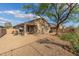 Spacious backyard with patio seating, desert plants, and a tree to provide shade to the gravel-covered area at 6520 E Hacienda La Noria Ln, Gold Canyon, AZ 85118