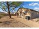 Exterior shot of backyard, showing desert landscaping, an air conditioning unit, and a shaded patio at 6520 E Hacienda La Noria Ln, Gold Canyon, AZ 85118