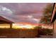 Backyard view of the sunset featuring block wall, desert plants, and the roofline of a home at 6520 E Hacienda La Noria Ln, Gold Canyon, AZ 85118
