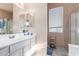 Bright bathroom featuring a shower, a large mirror, white cabinets, and a window with blinds at 6520 E Hacienda La Noria Ln, Gold Canyon, AZ 85118
