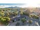 Expansive aerial view of a ranch-style home surrounded by mature landscaping, desert foliage and mountain views at 6615 E Desert Cove Ave, Scottsdale, AZ 85254