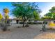 Well-maintained home featuring desert landscaping, mature trees, and a spacious front yard at 6615 E Desert Cove Ave, Scottsdale, AZ 85254