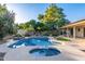 Refreshing pool and attached spa surrounded by desert landscaping, mature trees, and a covered patio at 6615 E Desert Cove Ave, Scottsdale, AZ 85254