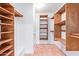 Well-organized walk-in closet with wooden shelving and hanging rods for ample storage at 6615 E Desert Cove Ave, Scottsdale, AZ 85254