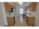 Efficient kitchen with tile floors, white appliances, wood cabinets and natural light, ideal for cooking at 6630 W Superior Ave, Phoenix, AZ 85043