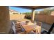 Covered patio with an outdoor dining set, creating a cozy space for entertaining or relaxing outdoors at 6820 S 68Th Ln, Laveen, AZ 85339