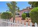 Desert landscaping with mature cactus and palm tree behind a white picket fence at 8637 E Solano Dr, Scottsdale, AZ 85250