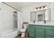 Bright bathroom featuring a shower over tub, a stylish vanity, and decorative mirror at 9050 N 51St Ln, Glendale, AZ 85302