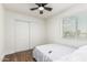 Bedroom featuring wood-look floors, a ceiling fan, a window, and a sliding door closet at 9050 N 51St Ln, Glendale, AZ 85302