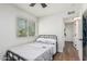 Bedroom featuring wood-look floors, a ceiling fan, and en-suite bathroom access at 9050 N 51St Ln, Glendale, AZ 85302