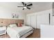 Bright bedroom featuring wood-look floors, ceiling fan, modern decor, and a sliding door closet at 9050 N 51St Ln, Glendale, AZ 85302