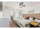 Bright bedroom featuring wood-look floors, ceiling fan, modern decor, and en-suite bathroom access at 9050 N 51St Ln, Glendale, AZ 85302