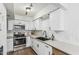 Updated kitchen with white cabinets, stainless steel appliances and modern fixtures at 9050 N 51St Ln, Glendale, AZ 85302
