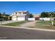 A two story home with a three car garage and extended drive way sits under a clear blue sky at 1015 S 132Nd St, Gilbert, AZ 85233