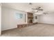 Spacious living room with a brick fireplace, neutral carpet, and plenty of natural light at 1028 W 5Th St, Mesa, AZ 85201