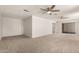 An open living room with neutral carpet, ceiling fan, and a sliding glass door at 1028 W 5Th St, Mesa, AZ 85201