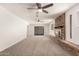 Living room with a brick fireplace, neutral carpet, and sliding glass doors at 1028 W 5Th St, Mesa, AZ 85201