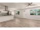 Bright living room featuring a ceiling fan, modern floors, and entry door with decorative glass at 1028 W 5Th St, Mesa, AZ 85201