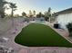 Lush backyard featuring artificial grass, a swimming pool, desert plants, and decorative rock at 1044 N Arvada N --, Mesa, AZ 85205