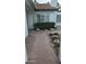 Inviting front entrance with a brick pathway, garden bed, large window and manicured shrubbery at 1044 N Arvada N --, Mesa, AZ 85205