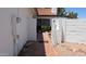 Brick walkway through a gated entrance, lined with white walls and desert landscaping elements at 1044 N Arvada N --, Mesa, AZ 85205