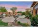 Secluded backyard featuring a pool, outdoor dining set, lush landscaping, and covered patio at 1073 N Layman St, Gilbert, AZ 85233
