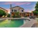 An illuminated swimming pool, patio with chairs and outdoor cooking area make this backyard perfect for entertaining at 1073 N Layman St, Gilbert, AZ 85233