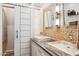 Modern bathroom featuring double sinks, stone walls, and white barn door at 1073 N Layman St, Gilbert, AZ 85233