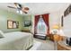 Comfortable bedroom with a ceiling fan, window with curtains, and a television at 1073 N Layman St, Gilbert, AZ 85233