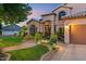 This home features a well maintained front yard with lush lawn, colorful plants and an extended driveway at 1073 N Layman St, Gilbert, AZ 85233