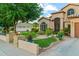 The beautiful home boasts mature landscaping, green lawn and a custom paver walkway to the front door and driveway at 1073 N Layman St, Gilbert, AZ 85233