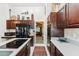 Open kitchen with dark cabinets, black appliances, island cooktop, and view to living area at 1073 N Layman St, Gilbert, AZ 85233