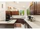 Bright kitchen with dark cabinets, white countertops, stainless steel appliances, and an island cooktop at 1073 N Layman St, Gilbert, AZ 85233