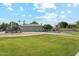Community park featuring playground, tennis court, swing set, and mature trees at 1073 N Layman St, Gilbert, AZ 85233