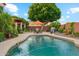 Inviting pool area with outdoor seating, barbecue grill, and lush landscaping at 1073 N Layman St, Gilbert, AZ 85233