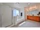 Well-lit bathroom with a soaking tub, glass shower, double vanity, and modern fixtures at 1114 S 220Th Ave, Buckeye, AZ 85326