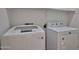 Laundry room with modern white washing machine and dryer set ready for use at 1114 S 220Th Ave, Buckeye, AZ 85326