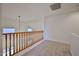 Upstairs hallway featuring wood railing and neutral carpet at 1114 S 220Th Ave, Buckeye, AZ 85326