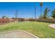 A large grassy backyard with a wooden fence and storage shed providing both privacy and functionality at 1186 E Brenda Dr, Casa Grande, AZ 85122