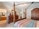Spacious main bedroom featuring a four poster bed, dresser and ensuite bathroom for added comfort at 1186 E Brenda Dr, Casa Grande, AZ 85122
