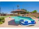 Inviting backyard swimming pool with a large inflatable float, surrounded by chairs and a lush lawn at 1186 E Brenda Dr, Casa Grande, AZ 85122