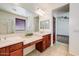A stylish primary bathroom features double sinks, vanity space, and a glass-enclosed shower at 12775 W Lowden Rd, Peoria, AZ 85383