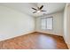 This is another shot of an empty bedroom with wood floors, ceiling fan, and window at 12775 W Lowden Rd, Peoria, AZ 85383