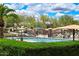 Resort-style community pool with ample seating, umbrellas, and lush landscaping, ideal for relaxation and recreation at 12775 W Lowden Rd, Peoria, AZ 85383