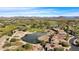 An aerial view showcasing a pond on a golf course, homes and a scenic landscape in the background at 12903 W Brookhart Way, Peoria, AZ 85383